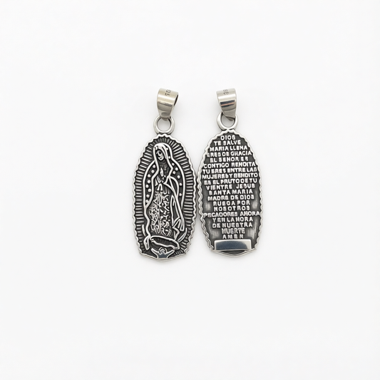 Two silver-toned religious pendants shown side by side on a plain white background, displaying the front and back engravings of Our Lady of Guadalupe.